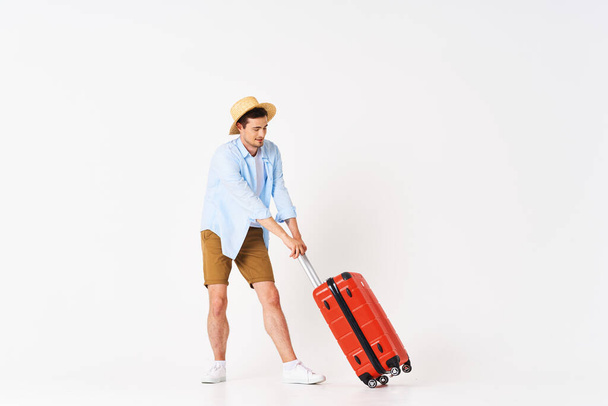 Studio shot of young man tourist  with suitcase - Photo, image