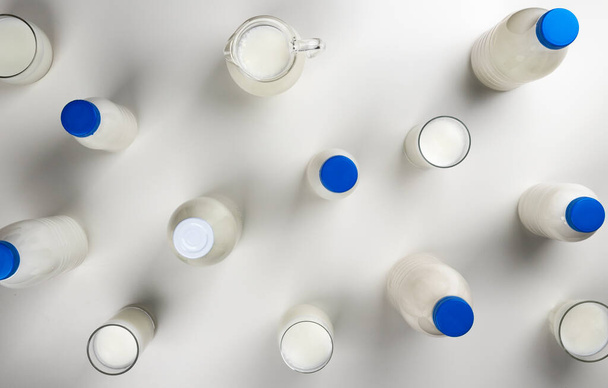 Emballage de produits laitiers, collecte de bouteilles et de verres avec lait et crème isolés sur fond blanc avec espace de copie, vue de dessus, pose plate - Photo, image