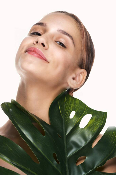 Young beautiful woman posing  with  leaf in studio - Photo, image