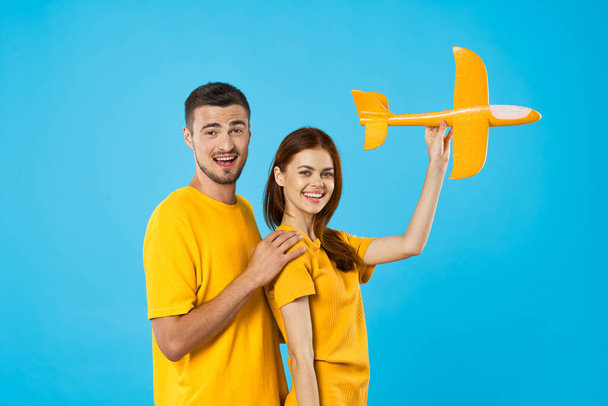 jeune couple avec jouet avion en studio, fond isolé    - Photo, image