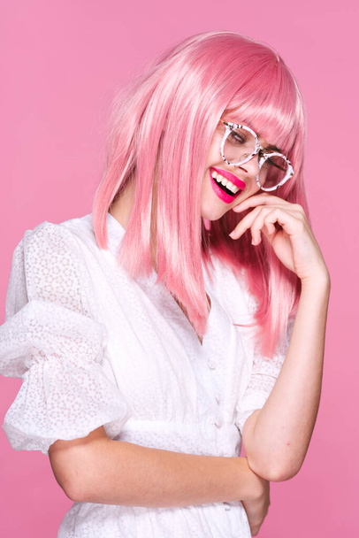 Στιγμιότυπο. Νεαρό κορίτσι με ροζ περούκα και γυαλιά σε ροζ φόντο - Φωτογραφία, εικόνα