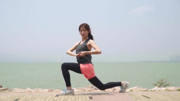 joven asiático mujer calentamiento hasta presionando piernas preparación para el ejercicio - Metraje, vídeo