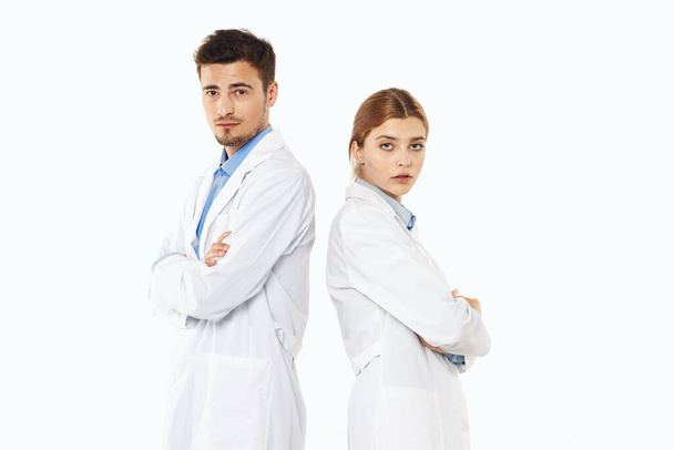 Νεαρός γιατρός και νοσοκόμα στο στούντιο, απομονωμένο υπόβαθρο.  - Φωτογραφία, εικόνα