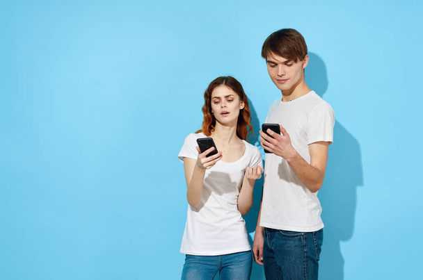 young couple with smartphones in studio  - Photo, Image