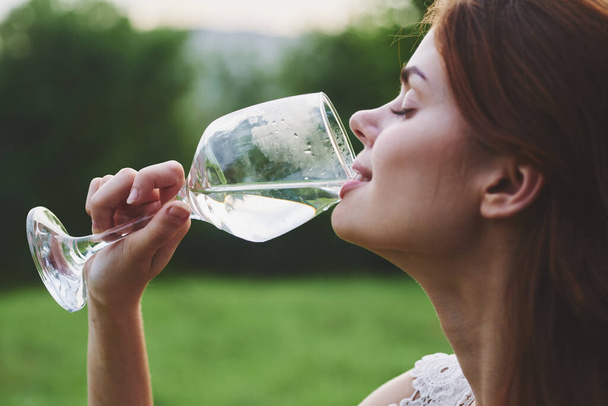νεαρή όμορφη γυναίκα πίνοντας κρασί στον κήπο  - Φωτογραφία, εικόνα