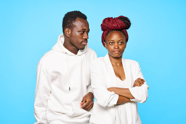 young beautiful couple posing in studio on blue background - Photo, Image
