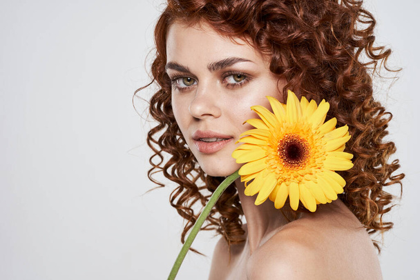 jong mooi vrouw met bloem poseren in studio, geïsoleerd  - Foto, afbeelding