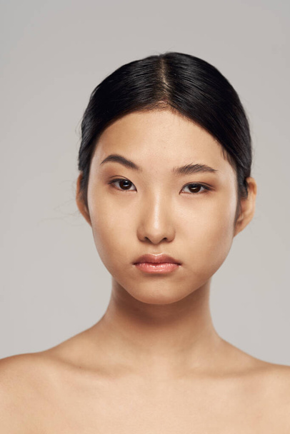 Retrato de joven hermosa mujer asiática aislada en gris  - Foto, imagen