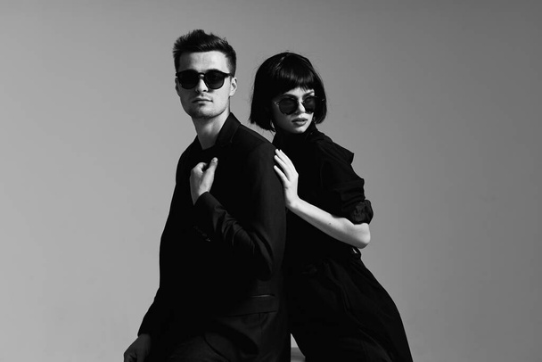 young beautiful stylish couple  in sunglasses  posing  in studio, isolated - Photo, Image