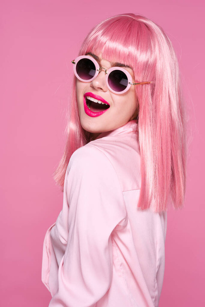 belle femme en perruque rose et lunettes de soleil posant  - Photo, image