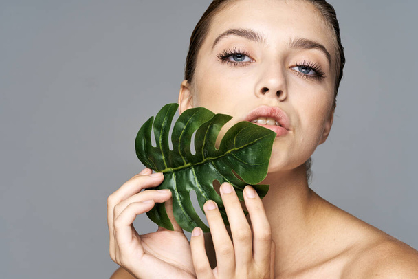 Young beautiful woman posing  with  leaf in studio - Foto, immagini