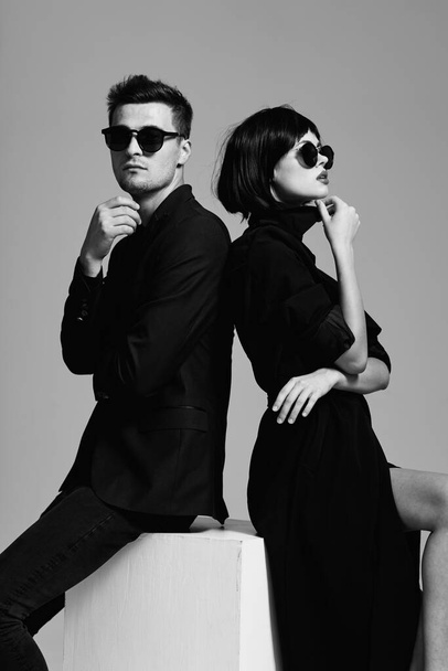 молода красива стильна пара в сонцезахисних окулярах позує в студії, ізольована
 - Фото, зображення