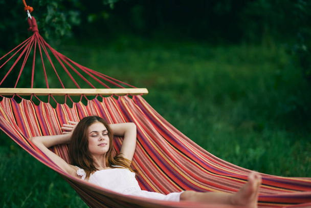 Young beautiful woman relaxing in hammock  - Фото, изображение