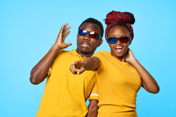 confused  couple in 3D glasses in studio on blue background - Foto, Imagen