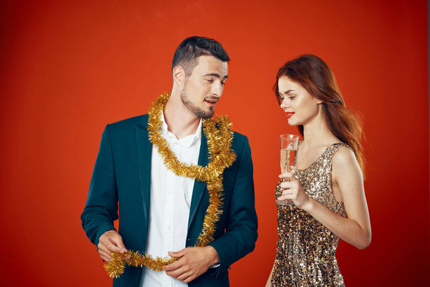 Junges schönes Paar feiert Neujahr auf rotem Hintergrund - Foto, Bild