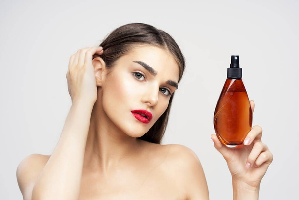 portrait of young beautiful woman holding beauty product in studio, isolated  - Photo, Image