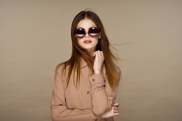  Young beautiful woman in sunglasses posing isolated on beige background   - Fotografie, Obrázek