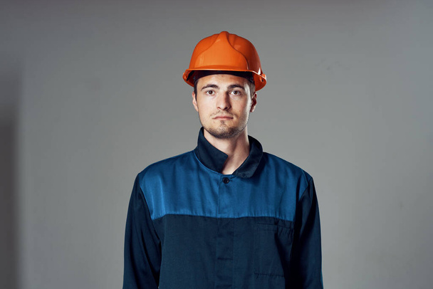Zdjęcia studyjne. Pracownik przemysłu w pomarańczowym hełmie stojący - Zdjęcie, obraz