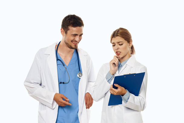 Young doctor and nurse in studio talking, isolated background.  - Photo, Image