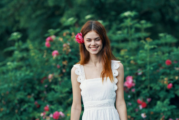 młoda piękna kobieta z czerwonym kwiatem w ogrodzie                           - Zdjęcie, obraz