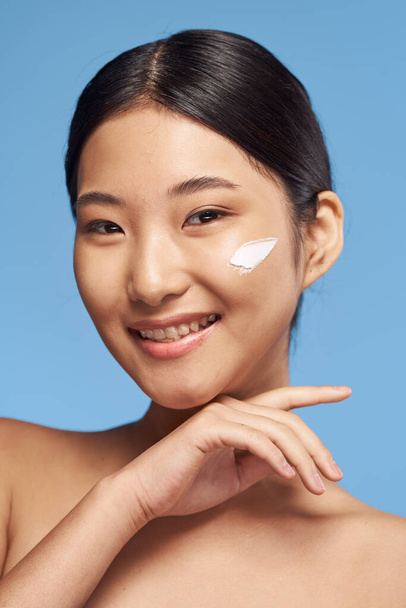 portrait de belle asiatique femme application crème sur fond isolé - Photo, image
