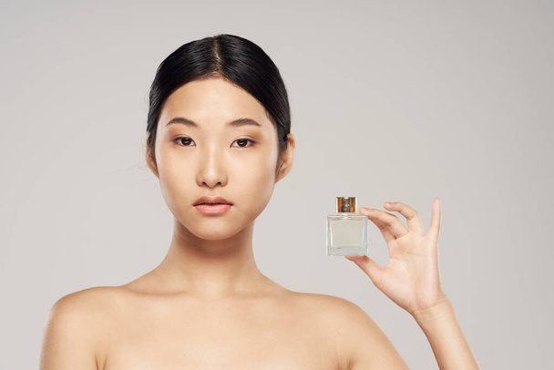 young beautiful  asian woman with perfume - Фото, изображение