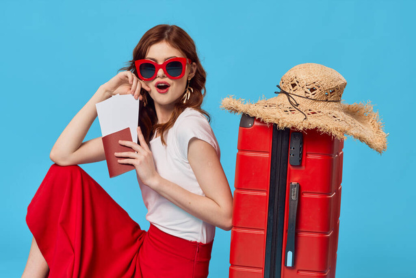 fiatal nő turista piros bőrönddel stúdióban              - Fotó, kép