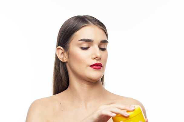 portrait of  beautiful woman holding beauty product on  isolated background - Fotó, kép