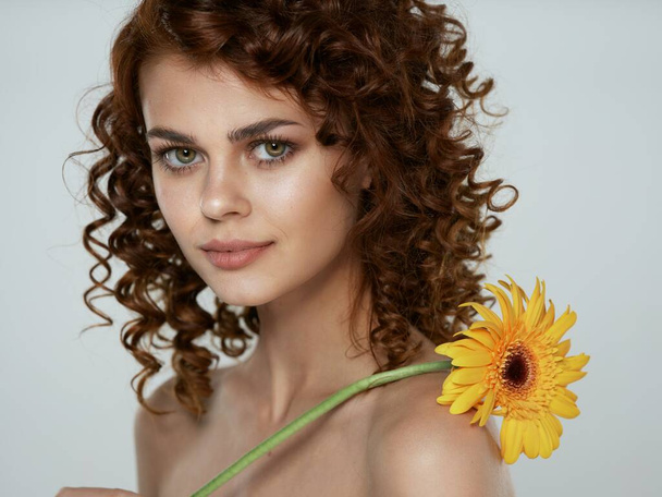 joven hermosa mujer sosteniendo flor en en estudio             - Foto, imagen