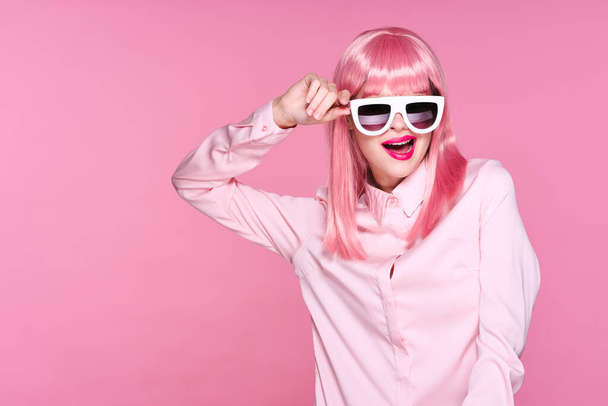beautiful woman in pink wig and sunglasses  on pink background - Photo, Image