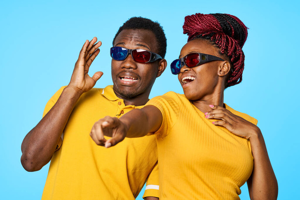 jong afrikaans paar wijzend in 3D bril in studio  - Foto, afbeelding