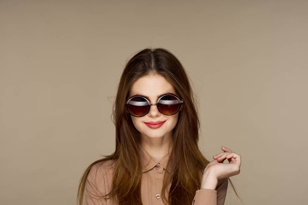  Young beautiful woman in sunglasses posing isolated on beige background   - Fotoğraf, Görsel