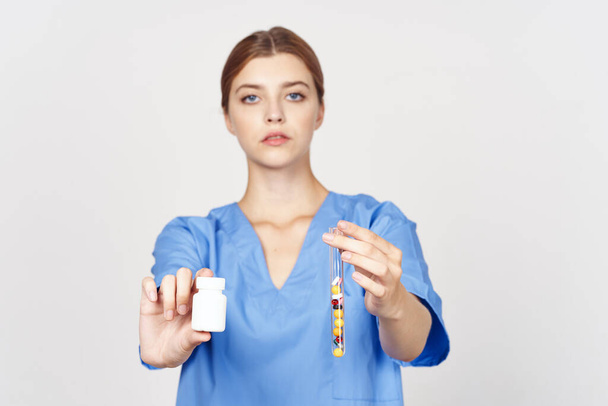 Foto de alta calidad. Mujer médico mostrando pastillas aisladas sobre fondo blanco  - Foto, Imagen