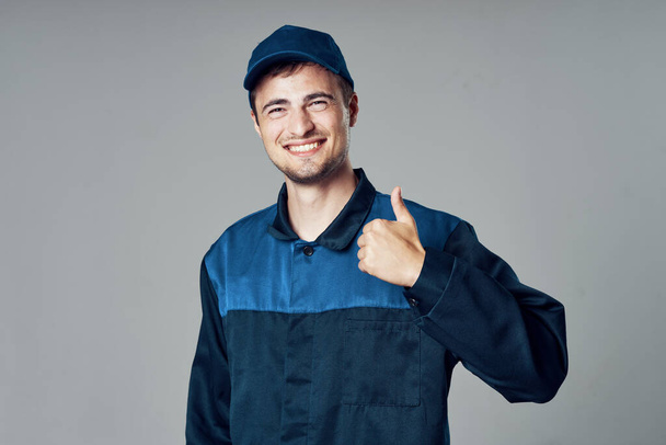 young handsome man in blue uniform with thumb up  - Photo, Image