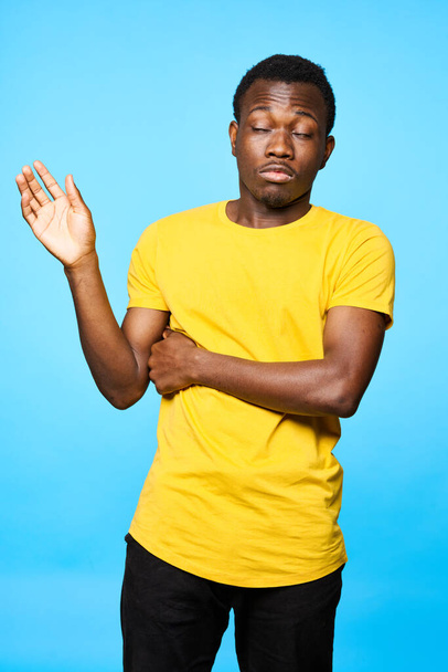 Young man showing palm    isolated on blue background - Photo, Image