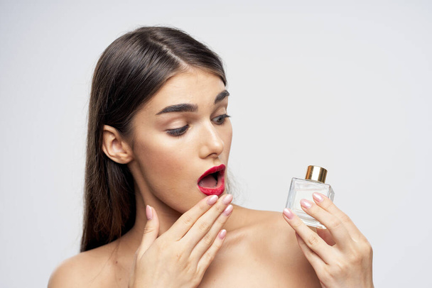 portrait  of young beautiful woman with perfume bottle  isolated  - Foto, Imagen