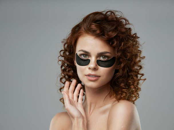 junge schöne Frau mit Augenklappen im Studio             - Foto, Bild