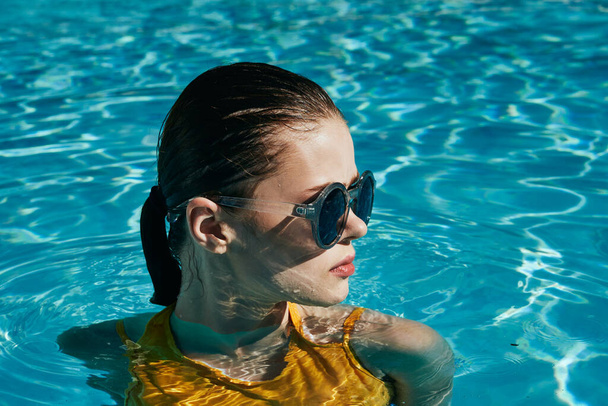 Fiatal gyönyörű nő napszemüvegben pihenés a medencében   - Fotó, kép