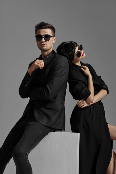joven hermosa pareja elegante en gafas de sol posando en el estudio, aislado - Foto, Imagen