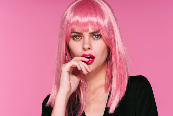 Фотография красивой женщины в розовом парике, позирующей на розовом фоне - Фото, изображение