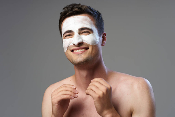Young handsome happy man with face mask   in studio  - Photo, Image