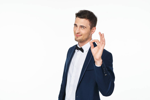 Young   man  showing ok   in studio,  isolated  background - Photo, image