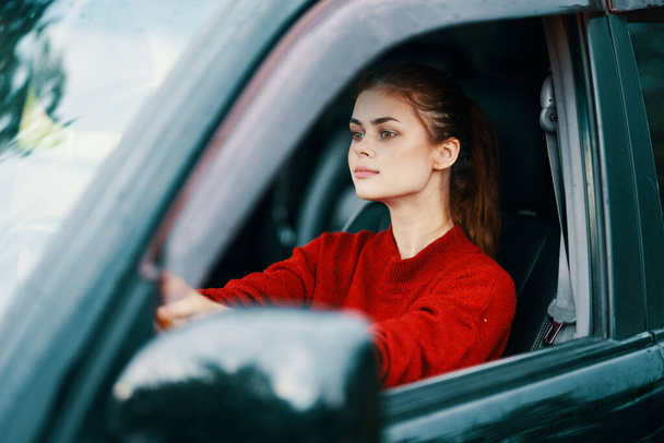 若い美しい女性が車を運転する - 写真・画像