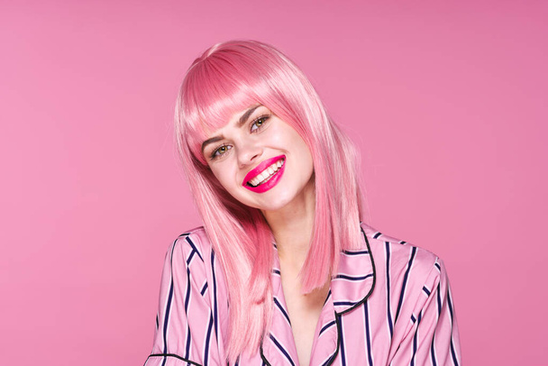 Sudio tiro de mulher bonita em peruca rosa sorrindo no fundo rosa - Foto, Imagem