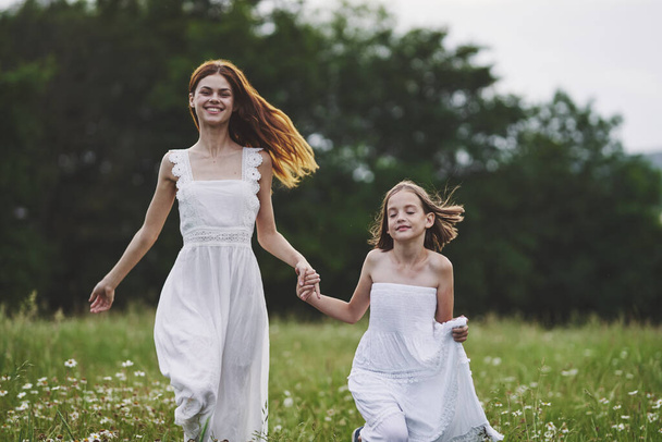 Молода мама і її дочка розважаються на ромашковому полі
 - Фото, зображення