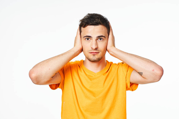 mladý pohledný muž uzavření uši izolované na bílém pozadí  - Fotografie, Obrázek