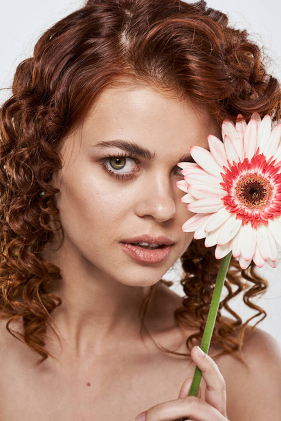 mladá krásná žena s kudrnaté vlasy s květinou ve studiu             - Fotografie, Obrázek