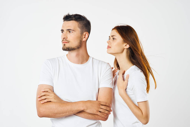 young beautiful couple in  t-shirts posing in studio on isolated background   - Foto, imagen