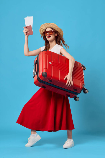 young woman  tourist with red suitcase in studio              - Foto, Imagen