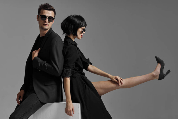 young beautiful stylish couple  in sunglasses  posing  in studio, isolated - Foto, afbeelding